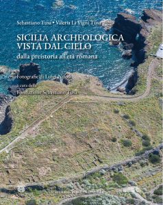 The cover of the book, which features an aerial photo of a cliff coastline. Traces of stone walls are visible on the land and a path runs along the edge of the cliff. The title and author information are printed mostly over the sea.